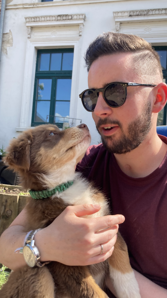 ich habe Nemo als Welpe auf dem Arm, er guckt mich an und ich lache etwas.